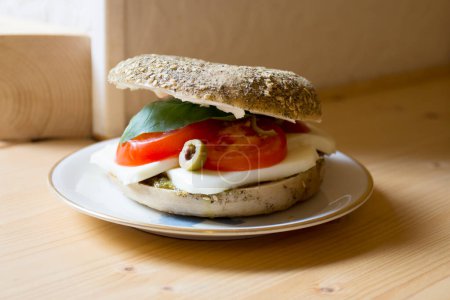 Photo for Delicious mozzarella sandwich on bagel bread. A bagel is a bread traditionally made from wheat flour and usually has a hole in the center. - Royalty Free Image