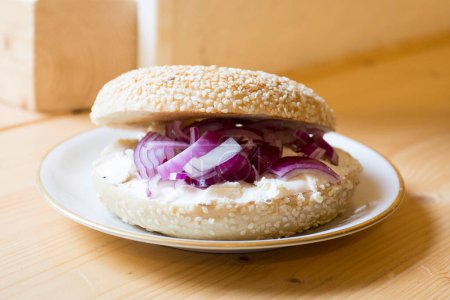 Téléchargez les photos : Délicieux fromage à la crème et sandwich à l'oignon sur pain bagel. - en image libre de droit