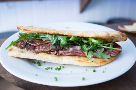 Foto de Delicioso sándwich con carne de res de primera calidad cortada y ensalada. - Imagen libre de derechos
