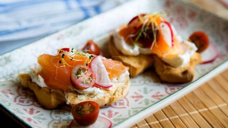 Téléchargez les photos : Deux toasts au pain bio avec fromage à la crème, radis et saumon fumé. - en image libre de droit