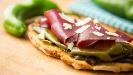 Photo for Traditional cecina tapa with fried green peppers. Cecina is a type of dehydrated meat of Spanish origin - Royalty Free Image