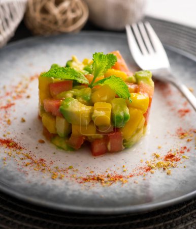 Photo for Avocado, mango and tomato tartare on a table with Christmas decorations. - Royalty Free Image