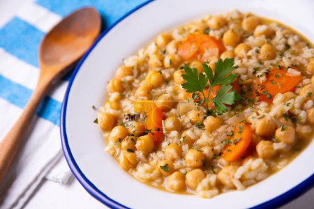 Photo for Typical Spanish dish of chickpea stew with vegetables such as carrots, peppers or zucchini. - Royalty Free Image