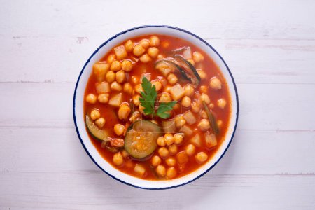 Photo for Typical Spanish dish of chickpea stew with vegetables such as carrots, peppers or zucchini. - Royalty Free Image