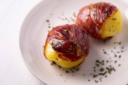 Photo for Boiled potatoes wrapped in serrano ham. Traditional Spanish tapa. - Royalty Free Image