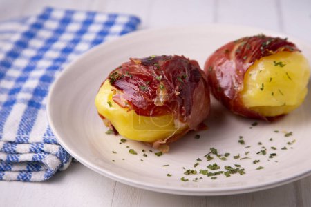Téléchargez les photos : Pommes de terre bouillies enveloppées dans du jambon serrano. Tapa espagnol traditionnel. - en image libre de droit