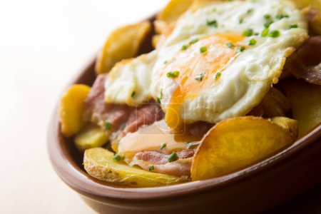 Téléchargez les photos : Œufs frits avec frites et jambon serrano. Tapa espagnole traditionnelle surnommée Huevos Rotos. - en image libre de droit