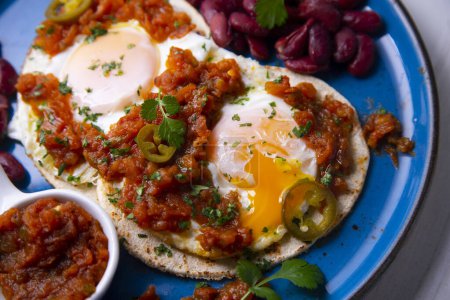 Photo for Huevos rancheros are a traditional Mexican breakfast, which basically consists of: fried eggs on corn tortillas with a sauce made from tomatoes, - Royalty Free Image