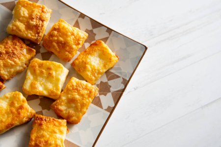 Téléchargez les photos : Petites pâtisseries feuilletées carrées au fromage gratin. - en image libre de droit
