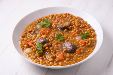 Photo for Lentil dish with potato, chorizo and black pudding. Traditional Spanish lentil stew with vegetables. - Royalty Free Image