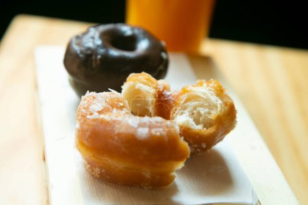 Foto de Un donut medio comido está en un papel blanco - Imagen libre de derechos