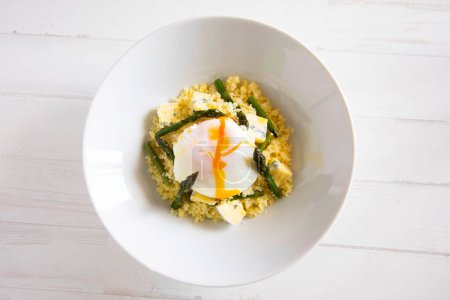 Photo for Couscous dish with a poached egg and green asparagus. - Royalty Free Image