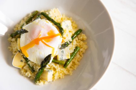 Téléchargez les photos : Plat de couscous avec œuf poché et asperges vertes. - en image libre de droit