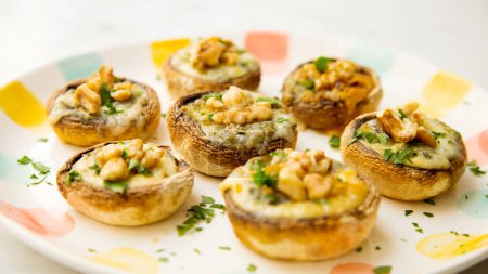 Téléchargez les photos : Champignons cuits au four farcis aux noix et au fromage. Tapa espagnol traditionnel. - en image libre de droit