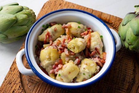 Photo for Tapa of braised artichokes with ham in a Spanish restaurant. - Royalty Free Image