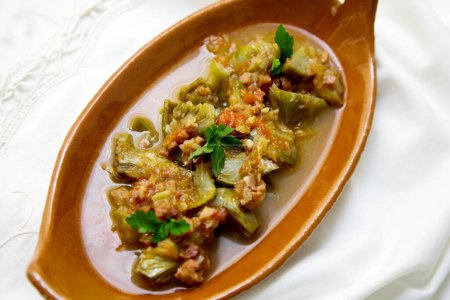 Foto de Tapa de alcachofas estofadas con jamón en un restaurante español. - Imagen libre de derechos