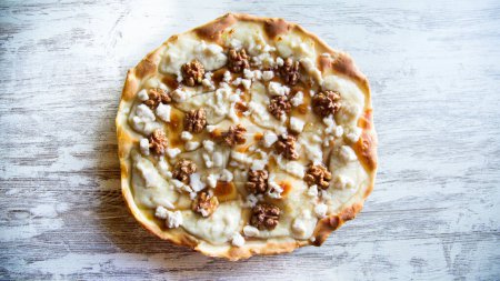 Foto de Pizza dulce con queso fresco, nueces y miel. Pizza napolitana hecha con receta italiana. - Imagen libre de derechos