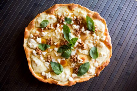 Téléchargez les photos : Pizza sucrée au fromage frais, noix et miel. pizza napolitaine à base de recette italienne. - en image libre de droit