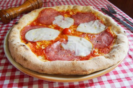 Foto de Salami Pizza. Pizza napolitana hecha con salami, queso y verduras horneadas. Receta vegetariana italiana. - Imagen libre de derechos