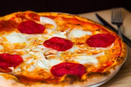 Foto de Salami Pizza. Pizza napolitana hecha con salami, queso y verduras horneadas. Receta vegetariana italiana. - Imagen libre de derechos