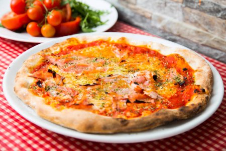 Photo for Prosciutto Pizza. Neapolitan pizza with tomato sauce, cheese and prosciutto ham. Authentic Italian recipe. - Royalty Free Image