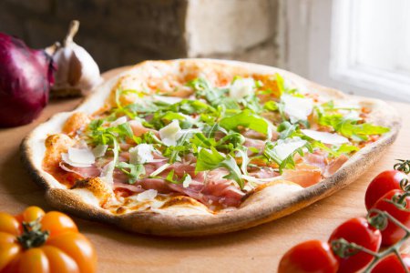 Foto de Pizza de jamón serrano. Pizza napolitana hecha con verduras horneadas y jamón serrano. Receta vegetariana italiana. - Imagen libre de derechos