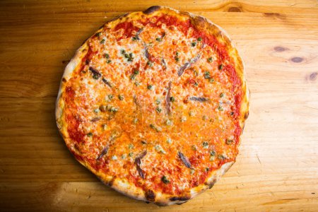 Téléchargez les photos : Pizza aux anchois. Pizza napolitaine au fromage mozzarella et anchois de la mer Méditerranée. Authentique recette italienne. - en image libre de droit