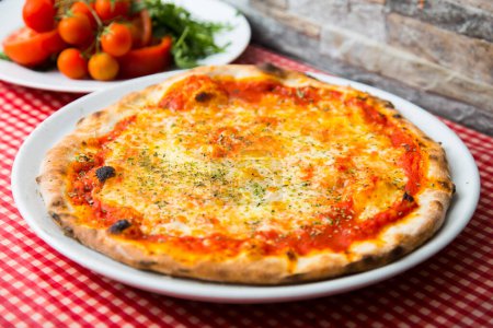 Foto de Margherita Pizza. Pizza napolitana elaborada con tomates San Marzano, queso mozzarella, albahaca fresca, sal y aceite de oliva virgen extra. - Imagen libre de derechos
