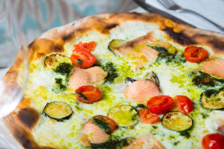 Photo for Salmon Pizza. Neapolitan pizza made with salmon and baked vegetables. Italian vegetarian recipe. - Royalty Free Image