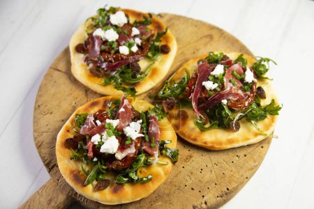 Photo for Mini pizza with arugula, Iberian ham and cheese. - Royalty Free Image