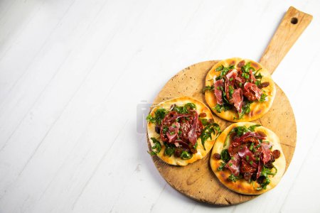 Photo for Mini pizza with arugula, Iberian ham and cheese. - Royalty Free Image
