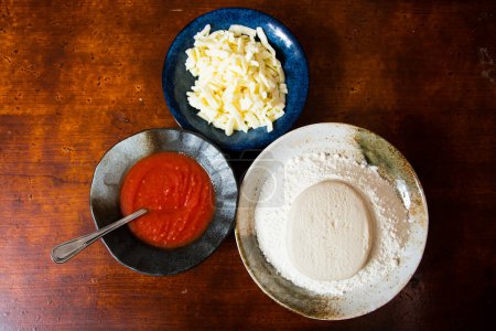 Foto de Preparando una pizza amasando la masa y cocinando con salsa de tomate casera italiana. - Imagen libre de derechos