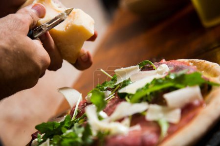 Foto de Carpaccio de carne de pizza. Pizza napolitana elaborada con salsa de tomate, queso y ternera. Receta italiana. - Imagen libre de derechos