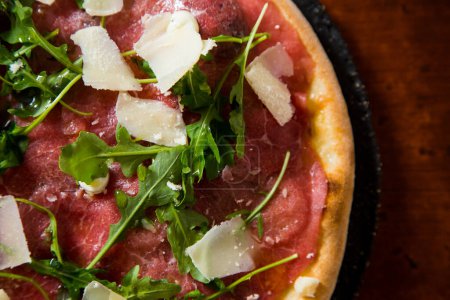Téléchargez les photos : Carpaccio de bœuf à pizza. Pizza napolitaine à base de sauce tomate, fromage et boeuf. Recette italienne. - en image libre de droit