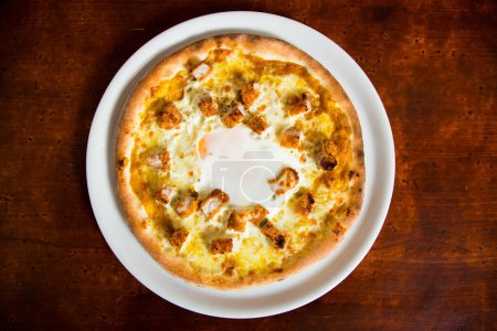 Photo for Pizza with breaded pork, curry and egg. Neapolitan pizza made with mozzarella. Italian recipe. - Royalty Free Image