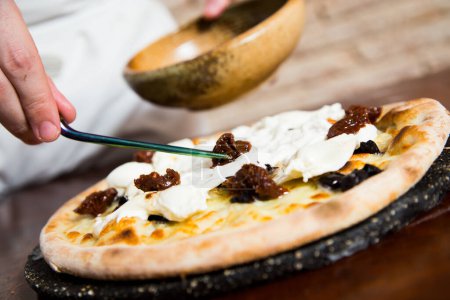 Foto de Pizza napolitana con burrata y aceitunas negras. - Imagen libre de derechos