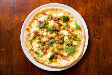 Foto de Pizza con rúcula de carne y queso. Pizza napolitana hecha con mozzarella. Receta italiana. - Imagen libre de derechos
