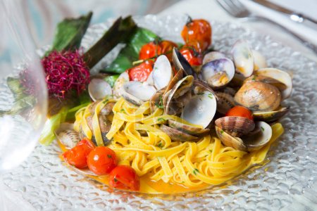 Photo for Nero di cuttlefish frutti di mare pasta recipe. Pasta combined with mussels, clams and prawns, fried tomato and garlic - Royalty Free Image