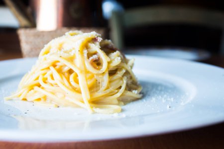 Photo for Carbonara or Carbonata is an Italian pasta dish originating from Lazio, and more specifically from Rome. The original recipe is based on eggs, cheese, extra virgin olive oil, pancetta or guanciale and black pepper. - Royalty Free Image