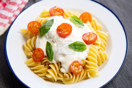 Photo for Italian fusilli pasta recipe with mozzarella sauce and cherry tomatoes - Royalty Free Image