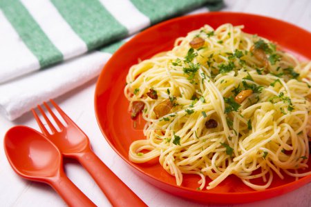 Foto de Spaghetti aglio e olio es un plato tradicional de pasta italiana de Nápoles. El plato se prepara salteando ligeramente el ajo picado o prensado en aceite de oliva, a veces con la adición de cayena seca, y agitando los espaguetis. - Imagen libre de derechos