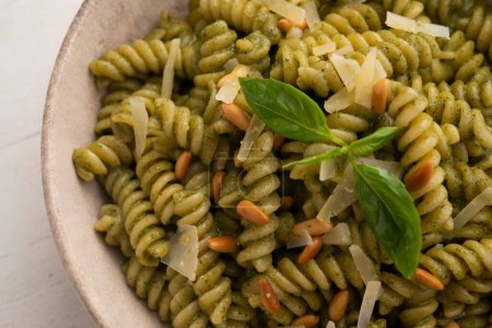 Téléchargez les photos : Pâtes avec sauce pesto. Pesto est une sauce typique originaire de Ligurie. Son ingrédient principal est le basilic. En plus du basilic, les pignons de pin et l'ail sont moulus, tous assaisonnés avec du parmesan et / ou du fromage de brebis, et de l'huile d'olive. - en image libre de droit