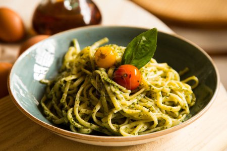 Téléchargez les photos : Nouilles à la sauce pesto. Pesto est une sauce typique originaire de Ligurie. Son ingrédient principal est le basilic. En plus du basilic, les pignons de pin et l'ail sont moulus, tous assaisonnés avec du parmesan et / ou du fromage de brebis, et de l'huile d'olive. - en image libre de droit