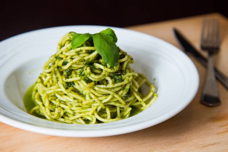 Photo for Noodles with pesto sauce. Pesto is a typical sauce originating from Liguria. Its main ingredient is basil. In addition to the basil, pine nuts and garlic are ground, all seasoned with Parmesan cheese and/or sheep cheese, and olive oil. - Royalty Free Image