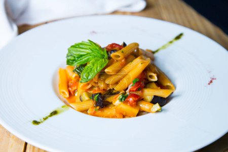 Téléchargez les photos : Pasta al pomodoro est un repas italien généralement préparé avec des pâtes, de l'huile d'olive, des tomates fraîches, du basilic et d'autres ingrédients frais. Il est conçu pour être un plat rapide et léger, plutôt qu'un plat avec une sauce épaisse. Pomodoro signifie "tomate" en italien. - en image libre de droit