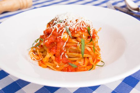 Photo for Noodles al pomodoro is an Italian meal typically prepared with pasta, olive oil, fresh tomatoes, basil, and other fresh ingredients. It is meant to be a quick and light dish, rather than a dish with a thick sauce. Pomodoro means "tomato" in Italian. - Royalty Free Image