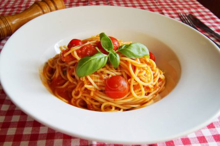 Photo for Noodles al pomodoro is an Italian meal typically prepared with pasta, olive oil, fresh tomatoes, basil, and other fresh ingredients. It is meant to be a quick and light dish, rather than a dish with a thick sauce. Pomodoro means "tomato" in Italian. - Royalty Free Image