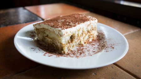 Téléchargez les photos : Tiramisu est un gâteau froid qui est assemblé en couches. Café, chocolat en poudre et mascarpone sont les principaux ingrédients de ce dessert italien. - en image libre de droit