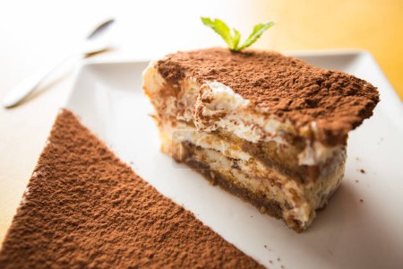 Tiramisu ist ein kalter Kuchen, der in Schichten zusammengesetzt wird. Kaffee, Schokoladenpulver und Mascarpone sind die Hauptbestandteile dieses italienischen Desserts.