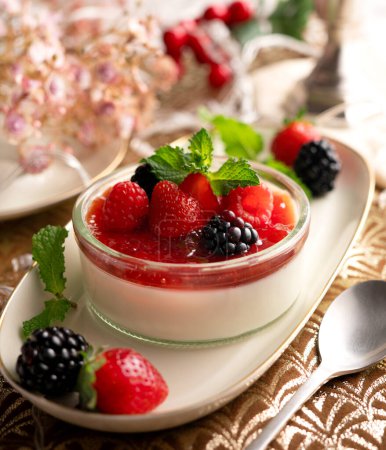 Photo for Panna cotta is a typical dessert from the Italian region of Piedmont, made from milk or cream, sugar and gelling agents, which is usually garnished with red fruit jams. - Royalty Free Image